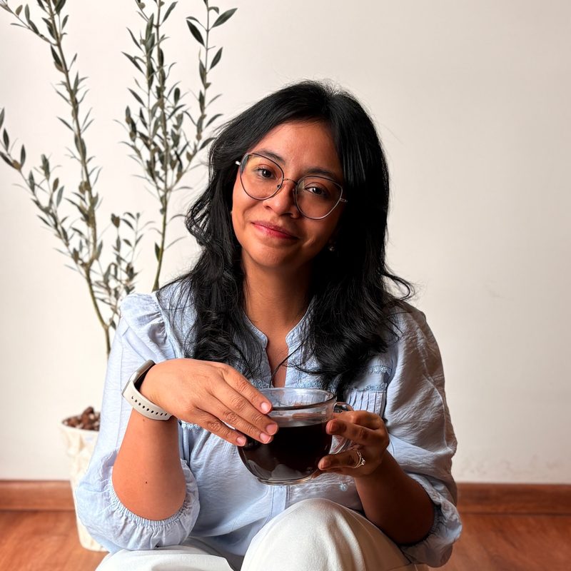 Dulce Ramírez, psicóloga, sonriendo con una taza de café en las manos